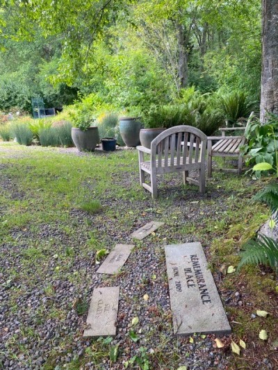 Remembrance Place (credit: Claudia Gorbman) Memorial stones on path near sitting area in garden.